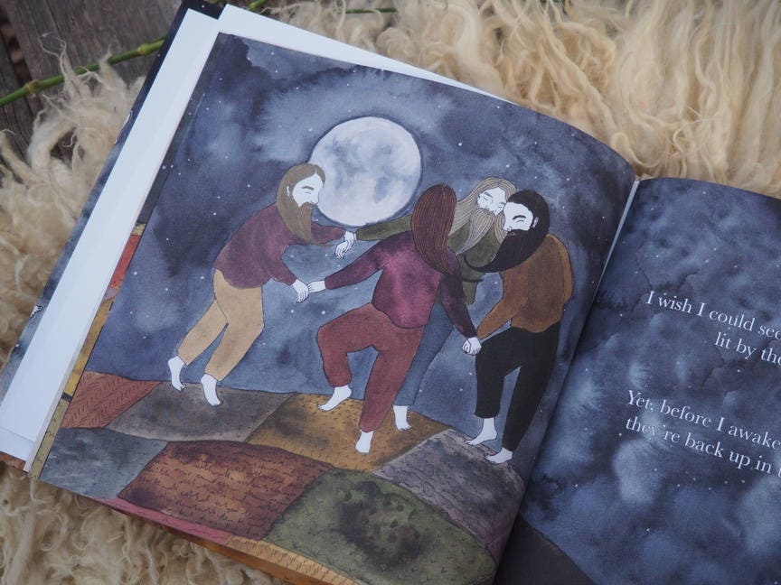 A book lays open showing a picture of four bearded giants dancing on quilted farmland under the full moon