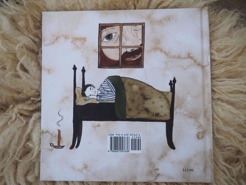 a closed book shows the back cover with a boy sleeping in bed and a giant smiling through the window