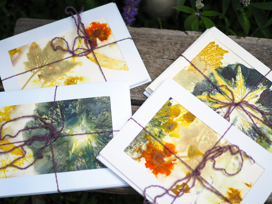 colorful flower and leaf prints decorate the front of four sets of note cards.  Each set is tied with purple yarn.