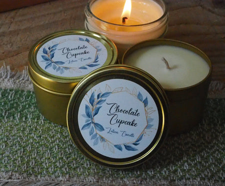 Three candles sit on a green woven fabric.  Two are open, one is lit.  The label says "Chocolate Cupcake Lotion Candle"